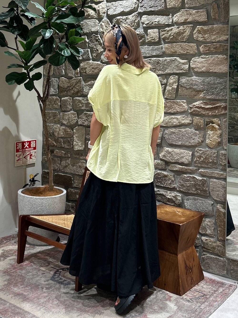 ブラック系のサンダル、ブラック系のスカート、イエロー系のシャツ/ブラウスを着用したレディースの夏コーディネートの3枚目の写真