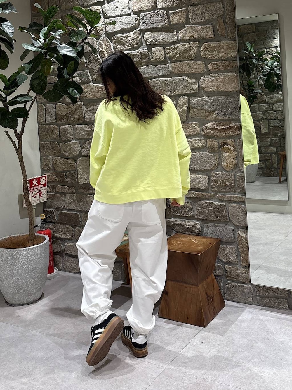 ホワイト系のスウェットパンツ、イエロー系のスウェットを着用したレディースの冬コーディネートの2枚目の写真