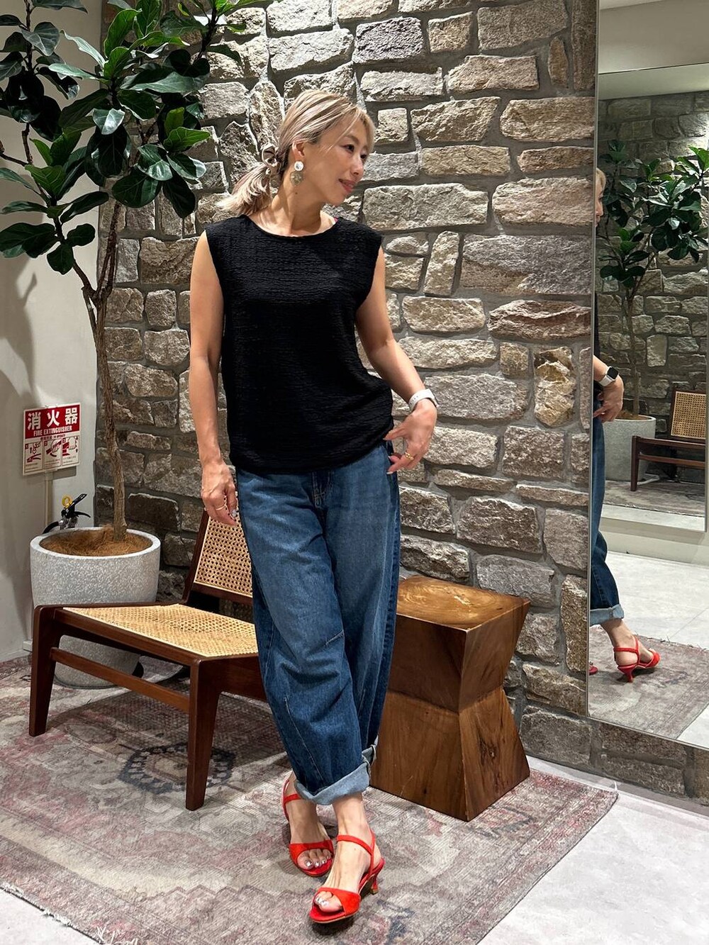 ブルー系のデニムパンツ、レッド系のサンダル、ブラック系のTシャツ/カットソーを着用したレディースの夏コーディネートの3枚目の写真