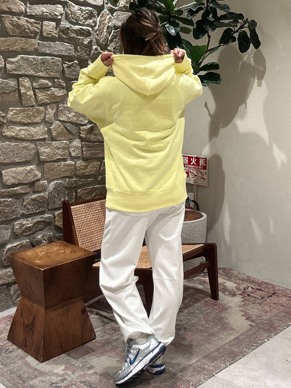 イエロー系のパーカー、ホワイト系のその他パンツを着用したレディースの冬コーディネートの2枚目の写真