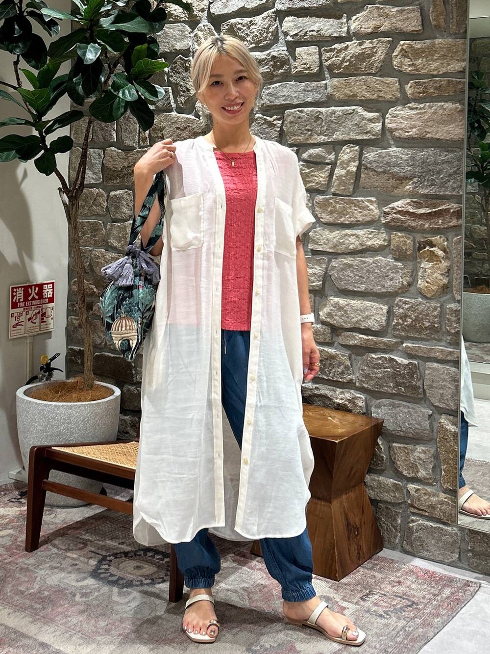 ブルー系のカーゴパンツ、ブラック系のトートバッグ、ホワイト系のサンダルを着用したレディースの夏コーディネートの2枚目の写真