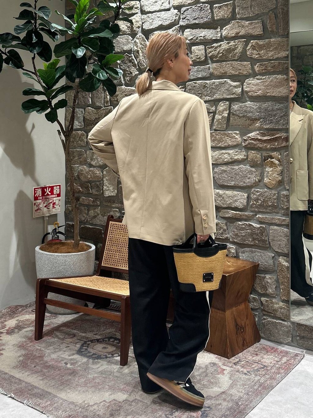 ベージュ系のテーラードジャケット、ブラック系のショルダーバッグ、グレー系のニット/セーターを着用したレディースの春コーディネートの3枚目の写真