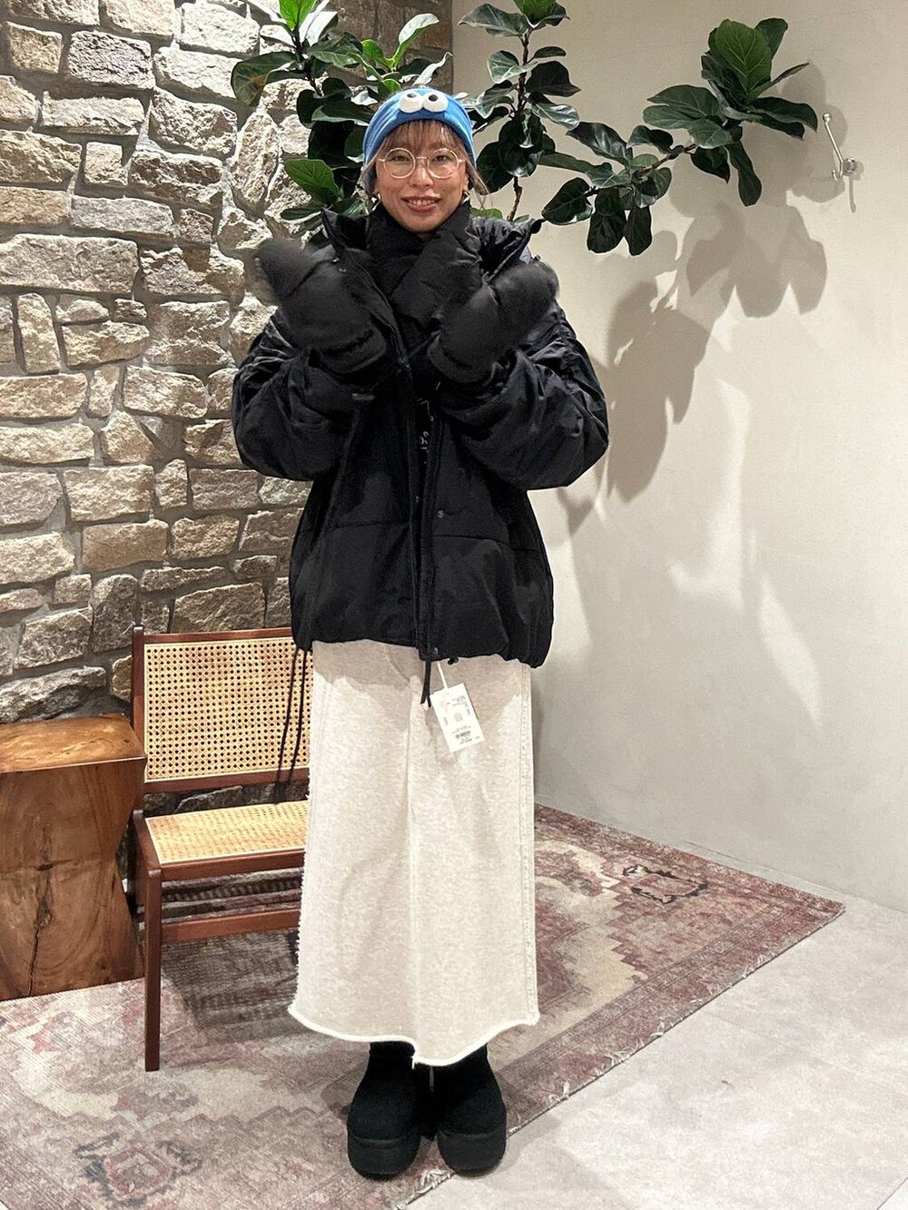 ブラック系のブルゾン、ブルー系のスウェット、ベージュ系のスカートを着用したレディースの冬コーディネートの2枚目の写真