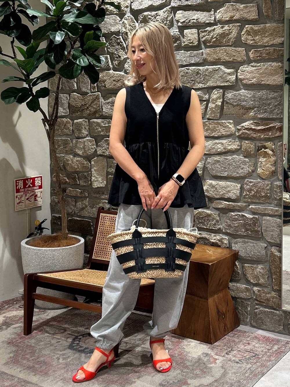 ブラック系のかごバッグ、レッド系のサンダル、グレー系のその他パンツを着用したレディースの夏コーディネートの3枚目の写真