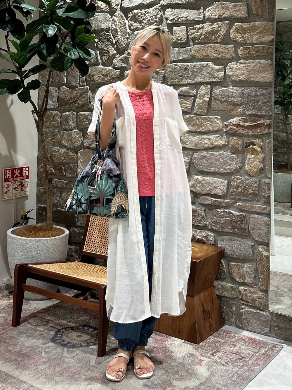 ブルー系のカーゴパンツ、ブラック系のトートバッグ、ホワイト系のサンダルを着用したレディースの夏コーディネートの3枚目の写真