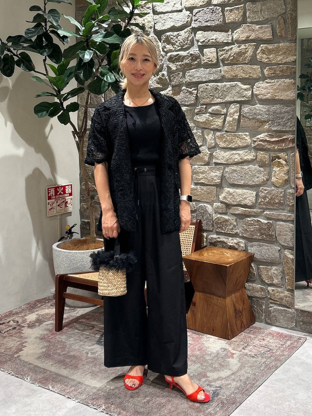 ブラック系のかごバッグ、ブラック系のその他パンツ、レッド系のサンダルを着用したレディースの夏コーディネートの2枚目の写真