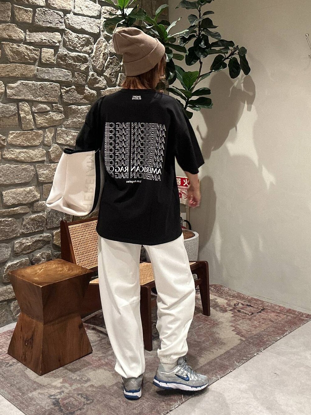 ベージュ系のトートバッグ、ホワイト系のその他パンツ、ベージュ系のニットキャップ/ビーニーを着用したレディースの冬コーディネートの3枚目の写真
