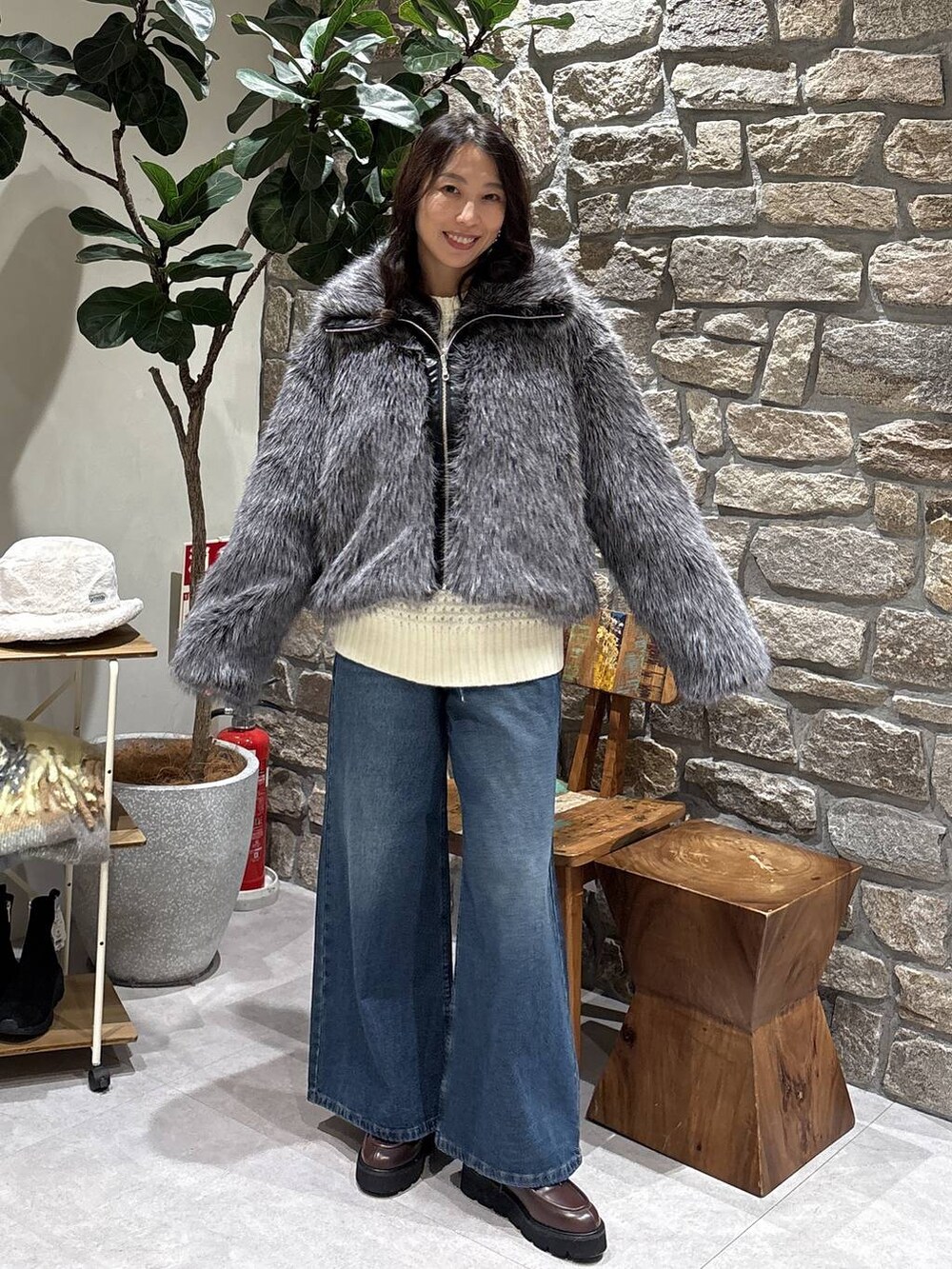 ブラウン系のブーツ、グレー系のブルゾン、ブルー系のデニムパンツを着用したレディースの冬コーディネートの2枚目の写真