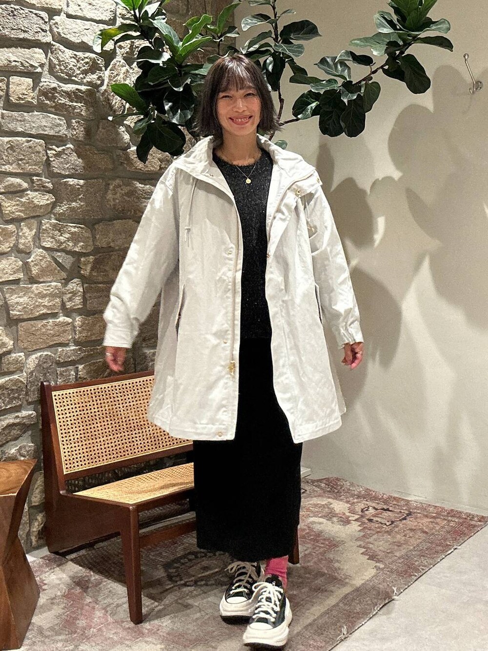 ブラック系のスカート、グレー系のマウンテンパーカー、ブラック系のニット/セーターを着用したレディースの秋コーディネートの2枚目の写真