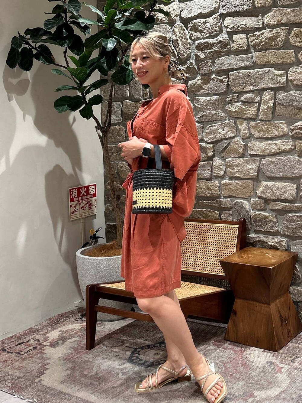 オレンジ系のシャツ/ブラウス、ブラウン系のその他パンツ、ブラック系のショルダーバッグを着用したレディースの夏コーディネートの2枚目の写真