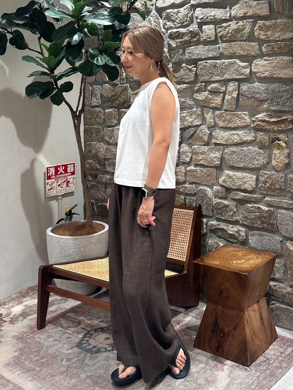 ブラウン系のその他パンツ、ホワイト系のTシャツ/カットソー、ブラック系のサンダルを着用したレディースの夏コーディネートの2枚目の写真