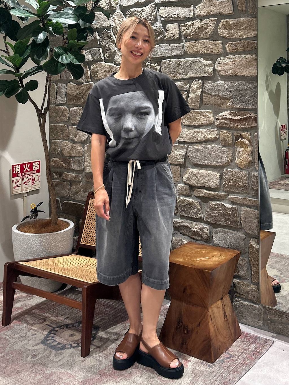 ブラック系のデニムパンツ、ブラウン系のサンダルを着用したレディースの夏コーディネートの3枚目の写真