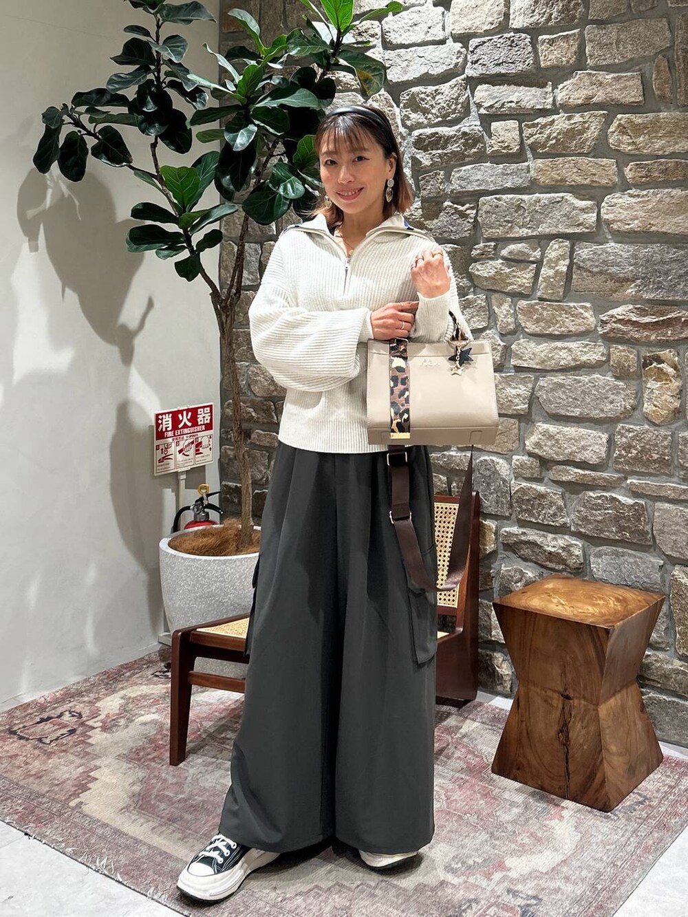 ベージュ系のハンドバッグ、グレー系のその他パンツ、ホワイト系のニット/セーターを着用したレディースの冬コーディネートの3枚目の写真