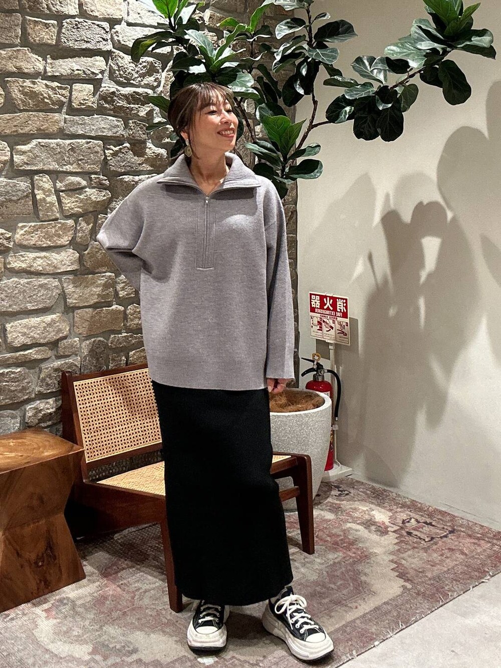 ブラック系のスカート、グレー系のニット/セーターを着用したレディースの秋コーディネートの4枚目の写真