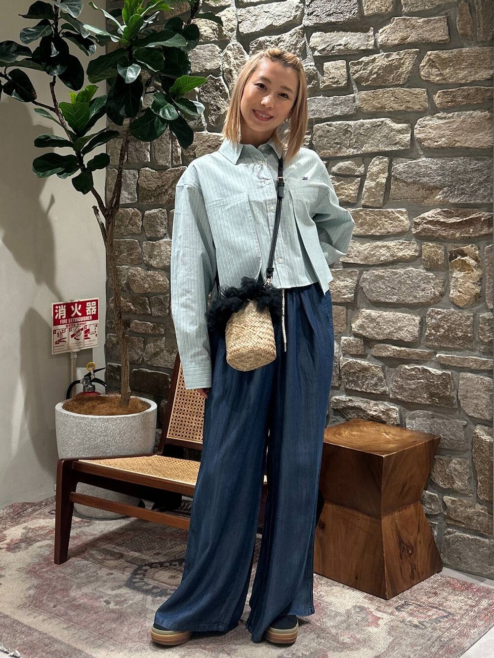 グリーン系のシャツ/ブラウス、ブルー系のその他パンツ、ブラック系のかごバッグを着用したレディースの春コーディネートの2枚目の写真