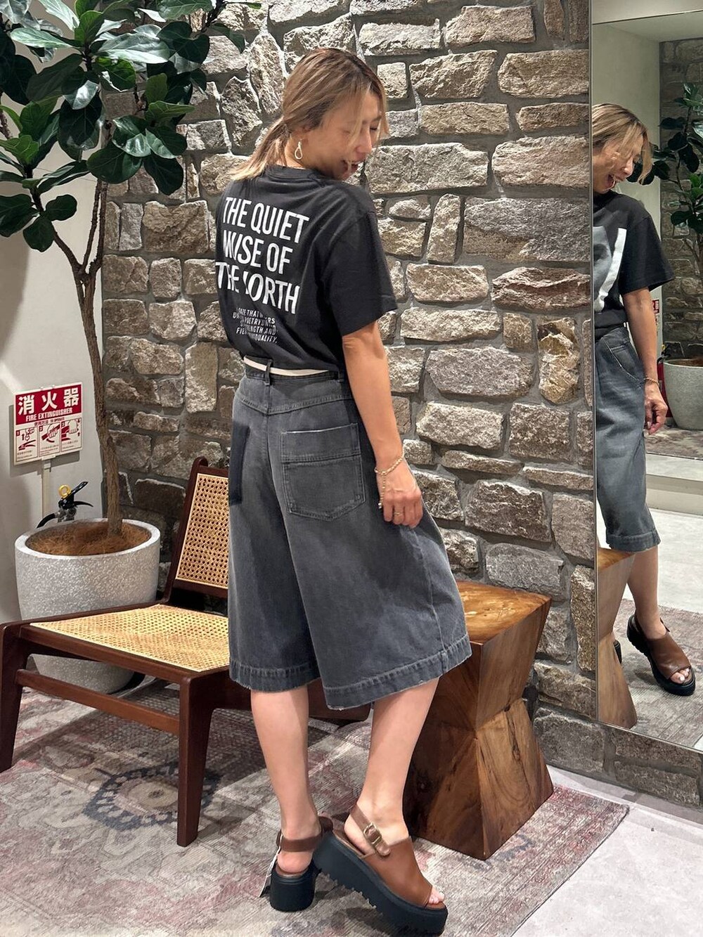 ブラック系のデニムパンツ、ブラウン系のサンダルを着用したレディースの夏コーディネートの2枚目の写真