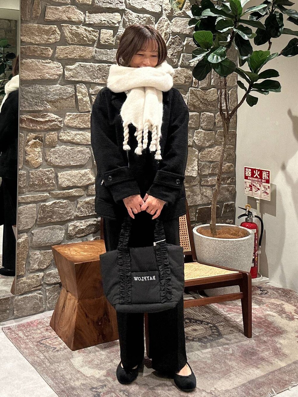 ブラック系のトートバッグ、ブラック系のライダースジャケット、ブラック系のその他パンツを着用したレディースの冬コーディネートの2枚目の写真