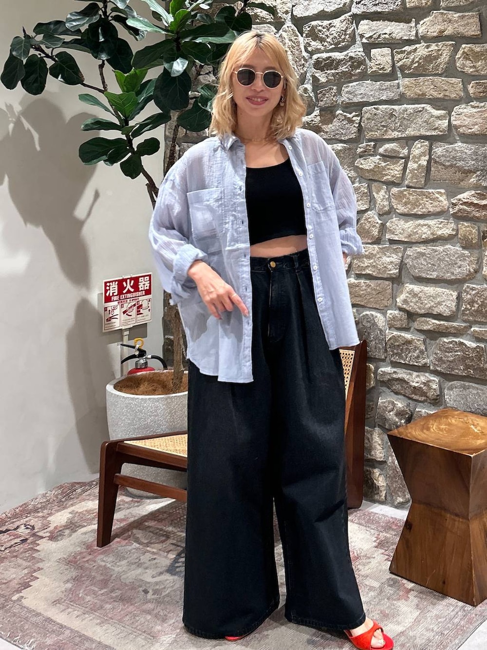 ブルー系のシャツ/ブラウス、レッド系のサンダル、ブラウン系のサングラスを着用したレディースの春コーディネートの3枚目の写真