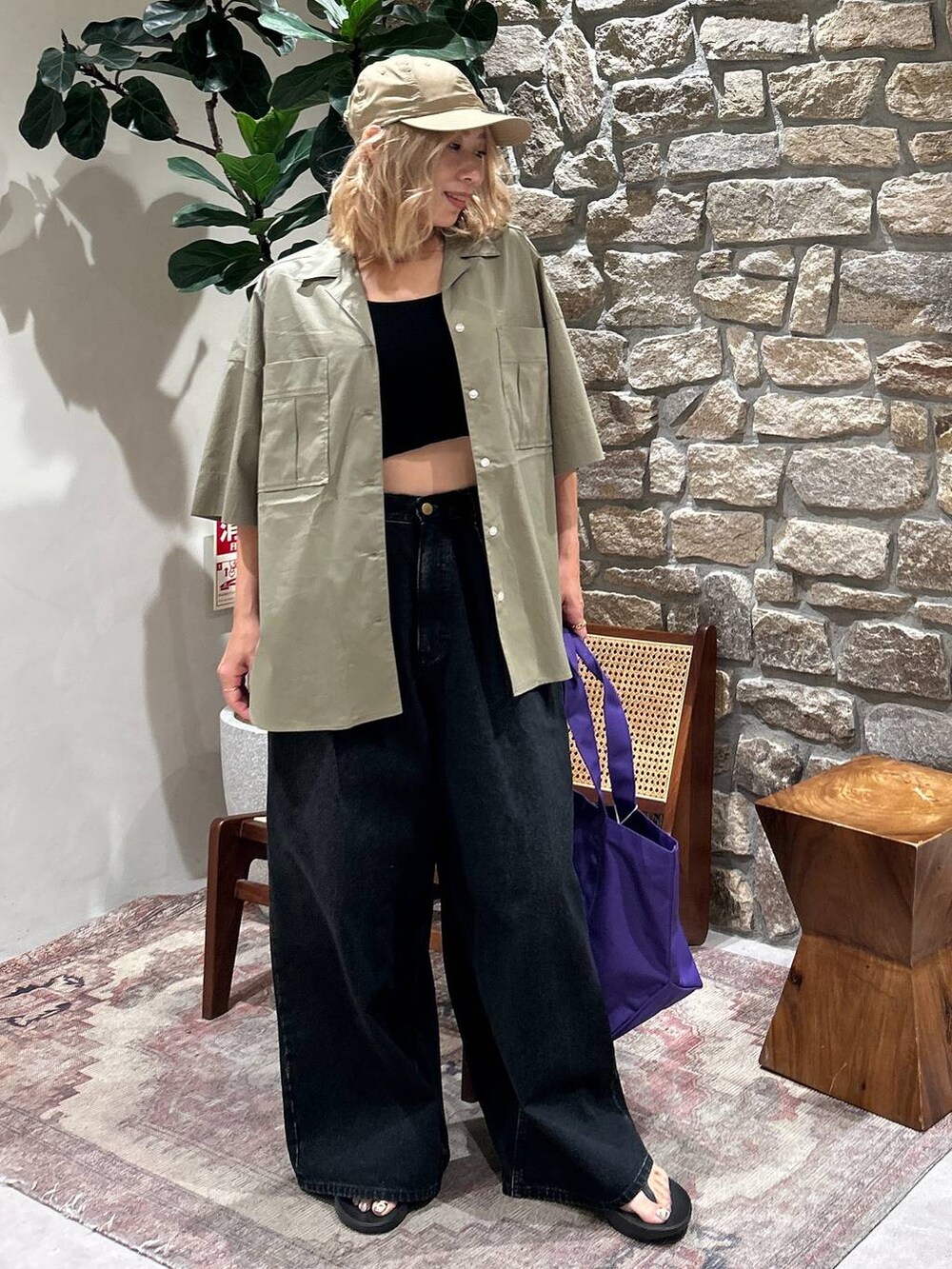 パープル系のトートバッグ、グリーン系のシャツ/ブラウス、ベージュ系のキャップを着用したレディースの春コーディネートの2枚目の写真