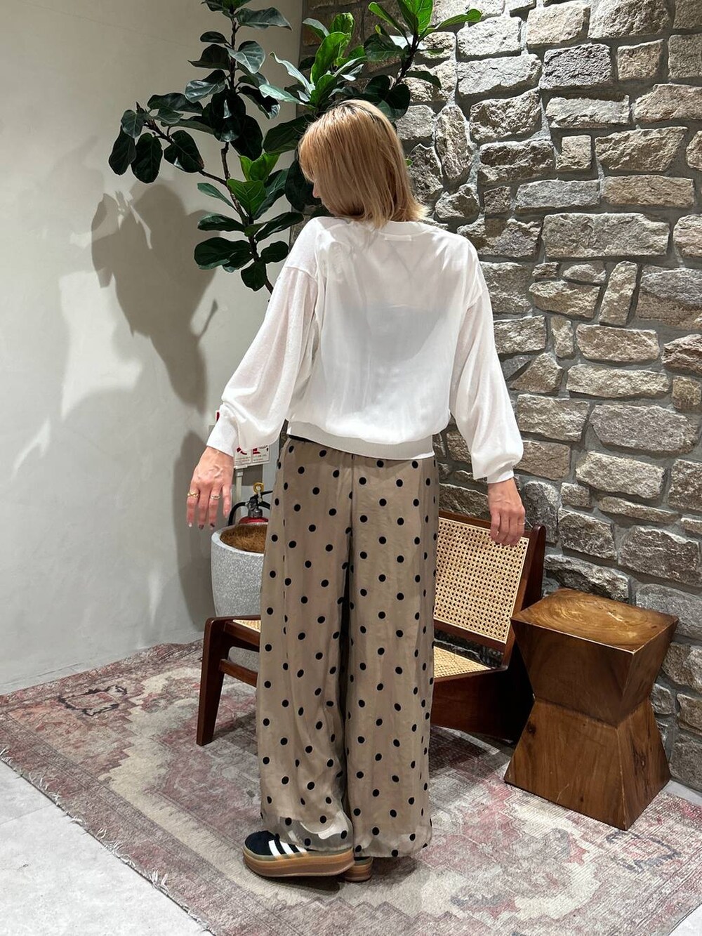 ブラック系のキャミソール、ホワイト系のカーディガン/ボレロ、ベージュ系のその他パンツを着用したレディースの春コーディネートの2枚目の写真