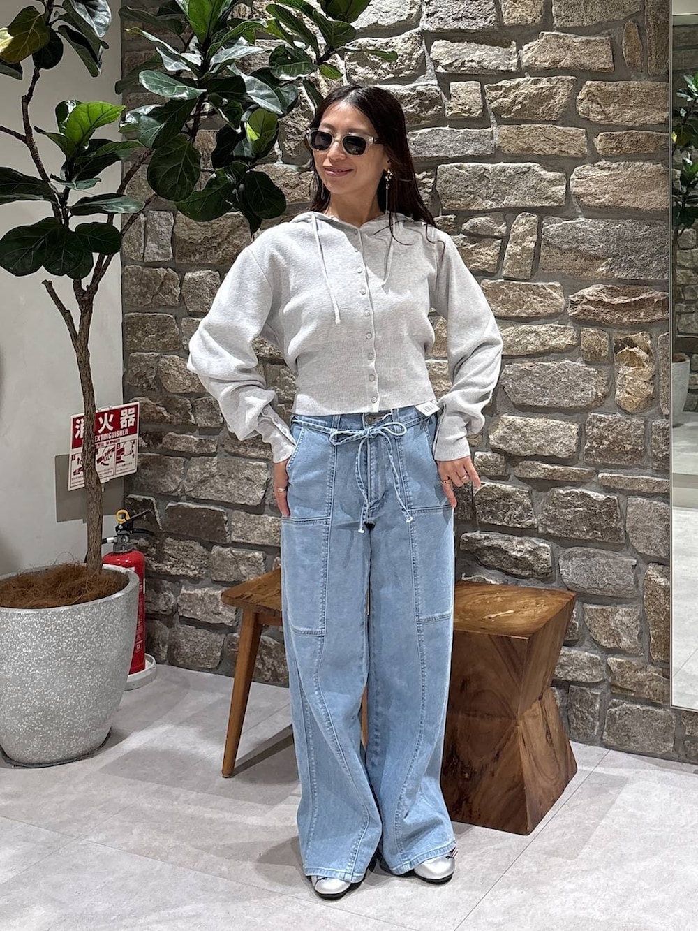 グレー系のスニーカー、グレー系のパーカー、イエロー系のサングラスを着用したレディースの春コーディネートの3枚目の写真