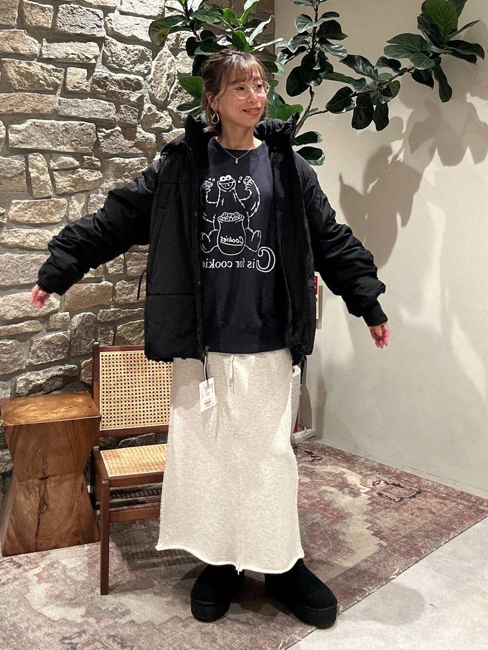 ブラック系のブルゾン、ブルー系のスウェット、ベージュ系のスカートを着用したレディースの冬コーディネートの4枚目の写真