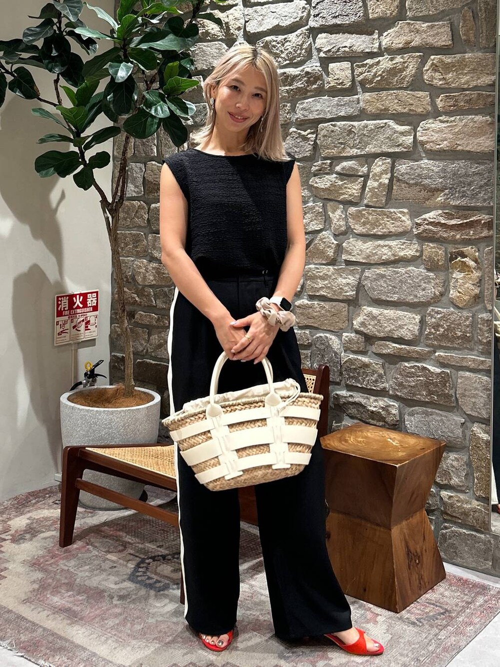 ホワイト系のかごバッグ、ブラック系のその他パンツ、レッド系のサンダルを着用したレディースの春コーディネートの2枚目の写真