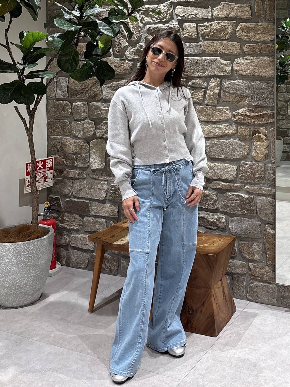 グレー系のスニーカー、グレー系のパーカー、イエロー系のサングラスを着用したレディースの春コーディネートの2枚目の写真