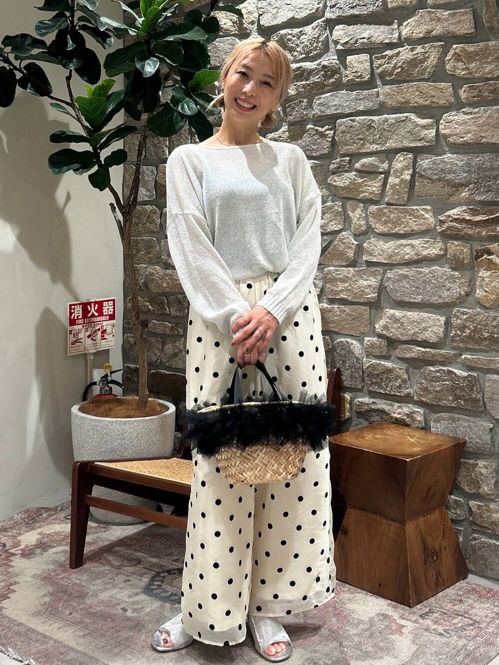 ブラック系のかごバッグ、ホワイト系のTシャツ/カットソー、シルバー系のサンダルを着用したレディースの春コーディネートの3枚目の写真