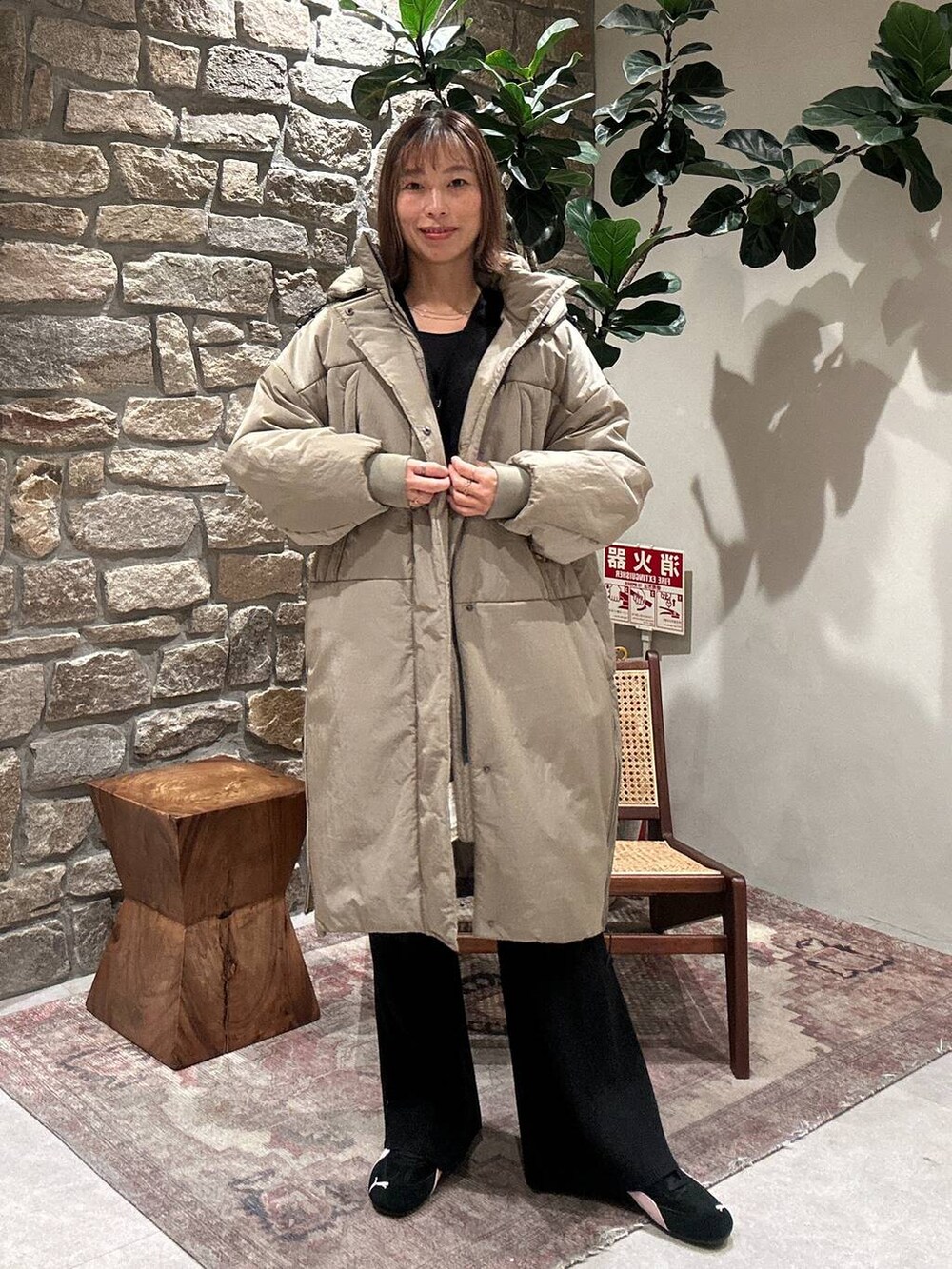 グリーン系のその他アウター、ブラック系のカーディガン/ボレロ、ブラック系のその他パンツを着用したレディースの冬コーディネートの3枚目の写真