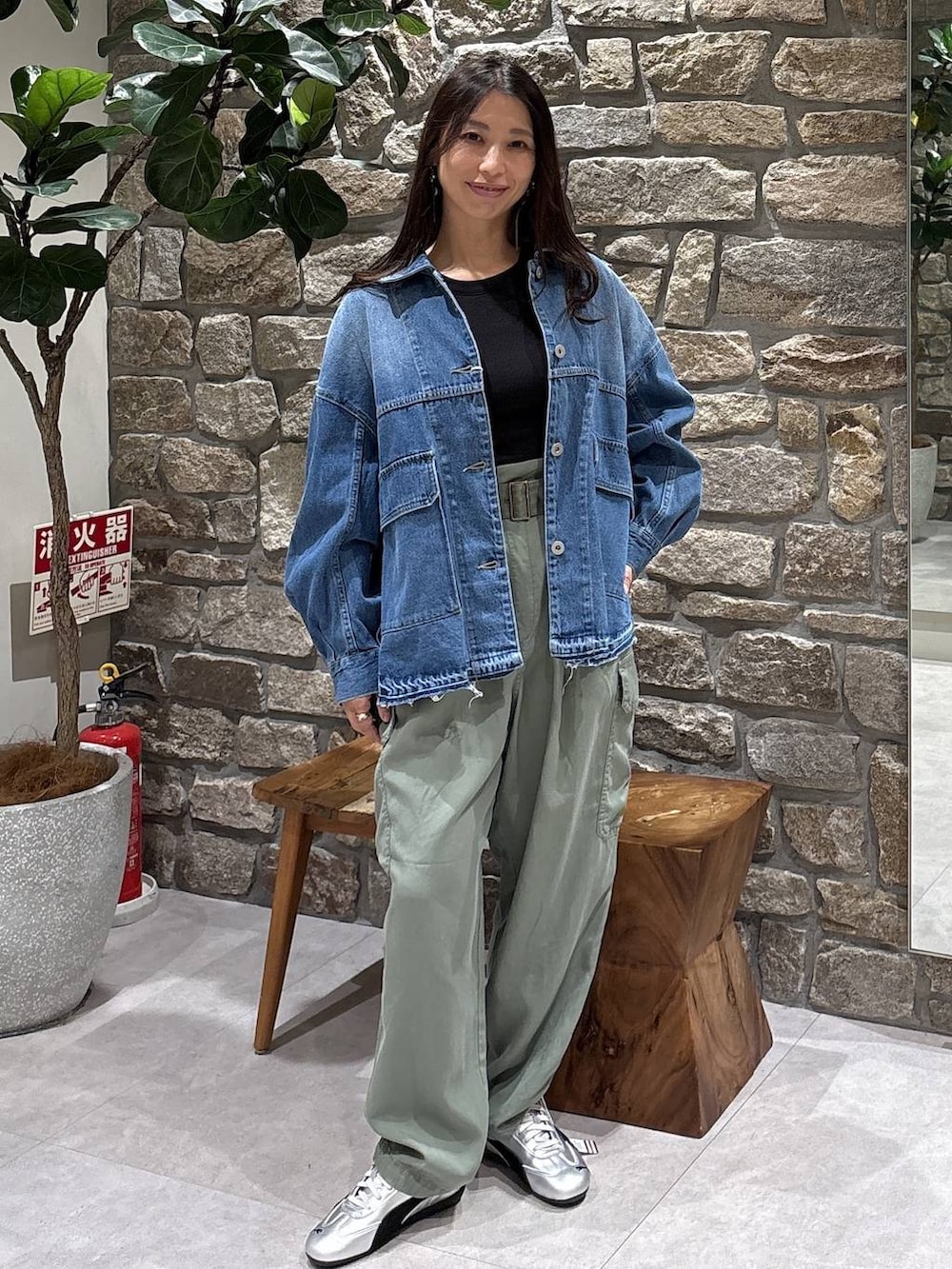 グレー系のスニーカー、グリーン系のカーゴパンツ、ブルー系のデニムジャケットを着用したレディースの春コーディネートの3枚目の写真