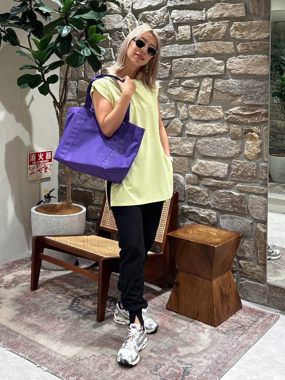 ブラック系のその他パンツ、ベージュ系のTシャツ/カットソー、パープル系のトートバッグを着用したレディースの春コーディネートの2枚目の写真