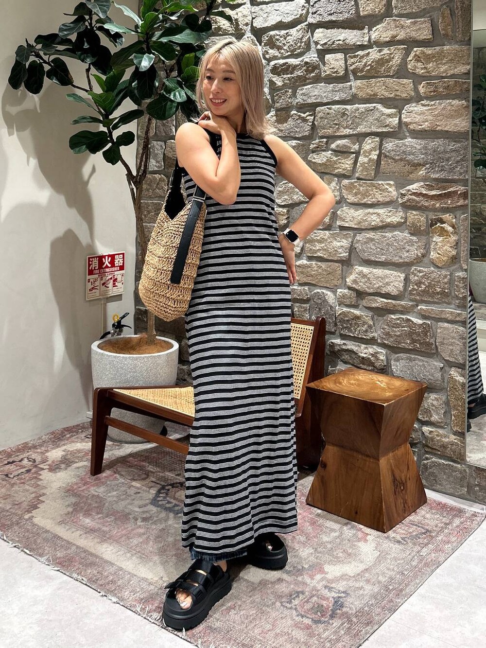 ブラック系のサンダル、ブルー系のデニムパンツ、ブラック系のワンピースを着用したレディースの夏コーディネートの2枚目の写真