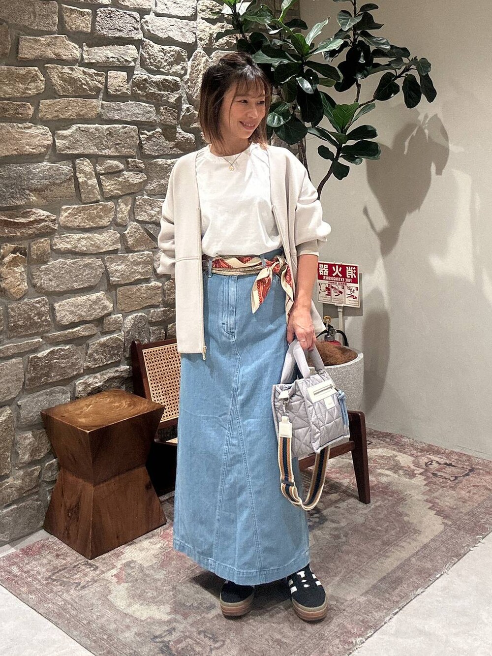 グレー系のショルダーバッグ、ベージュ系のブルゾン、ホワイト系のTシャツ/カットソーを着用したレディースの春コーディネートの2枚目の写真