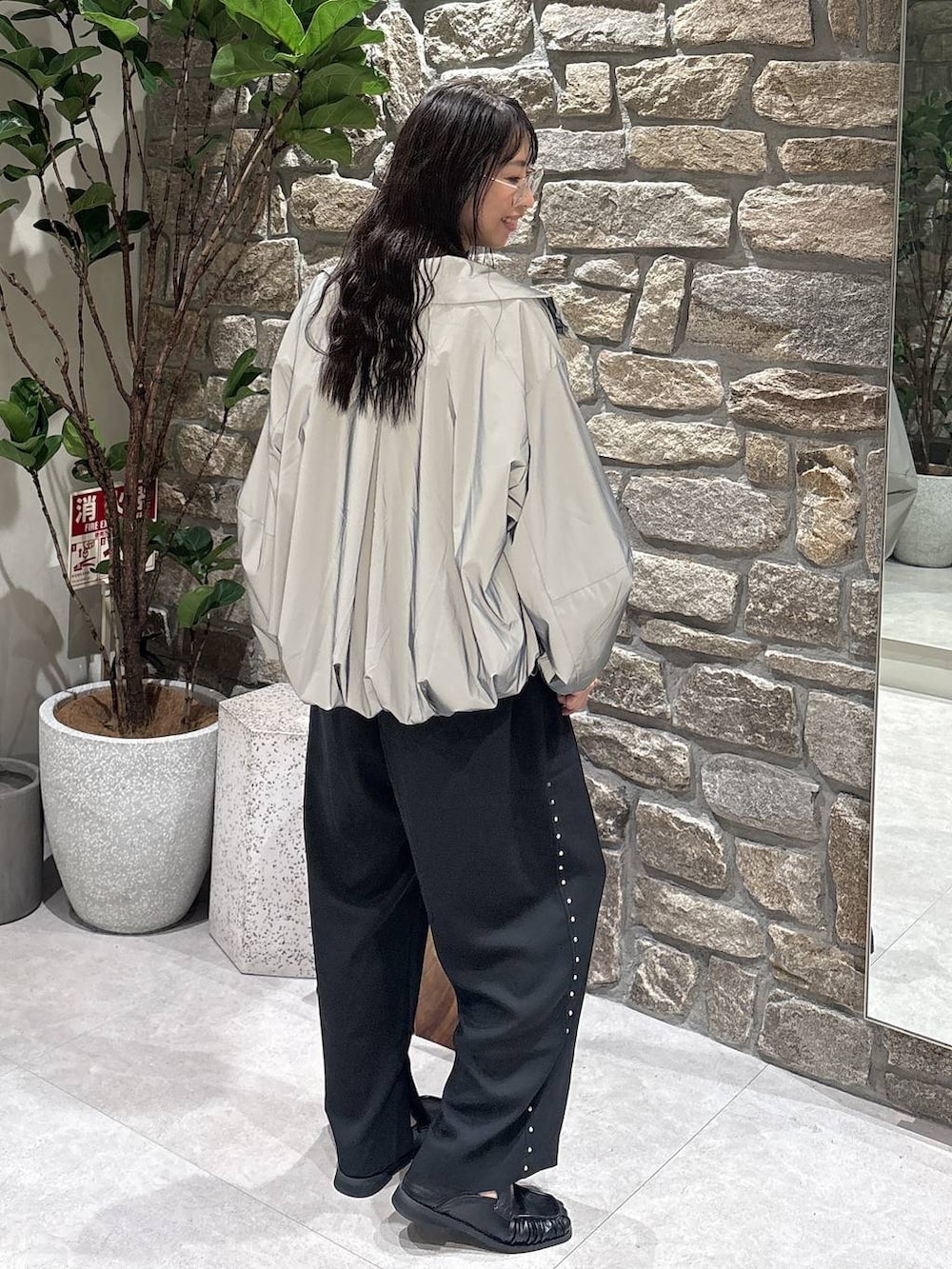ブラック系のスリッポン、ブラック系のその他パンツ、シルバー系のブルゾンを着用したレディースの秋コーディネートの2枚目の写真