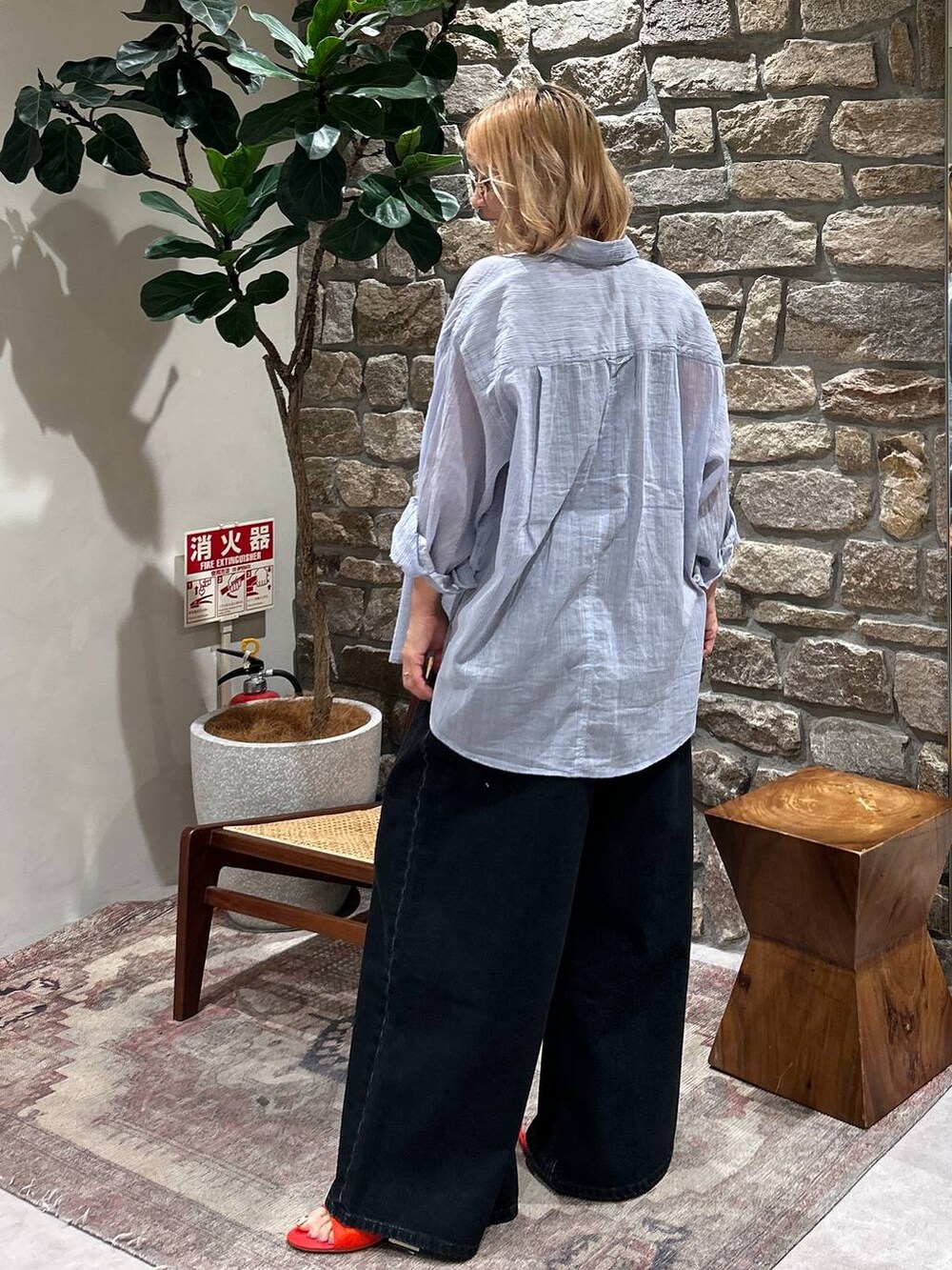 ブルー系のシャツ/ブラウス、レッド系のサンダル、ブラウン系のサングラスを着用したレディースの春コーディネートの2枚目の写真