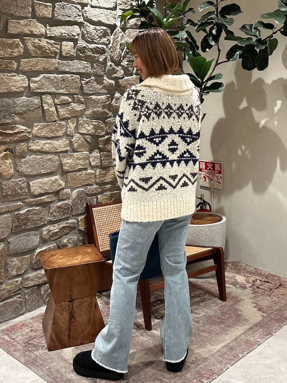 ブルー系のデニムパンツ、ブルー系のトートバッグ、ホワイト系のニット/セーターを着用したレディースの秋コーディネートの2枚目の写真