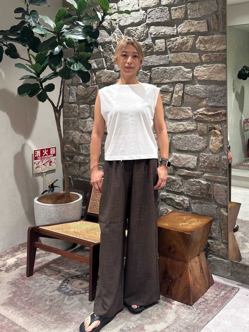 ブラウン系のその他パンツ、ホワイト系のTシャツ/カットソー、ブラック系のサンダルを着用したレディースの夏コーディネートの3枚目の写真