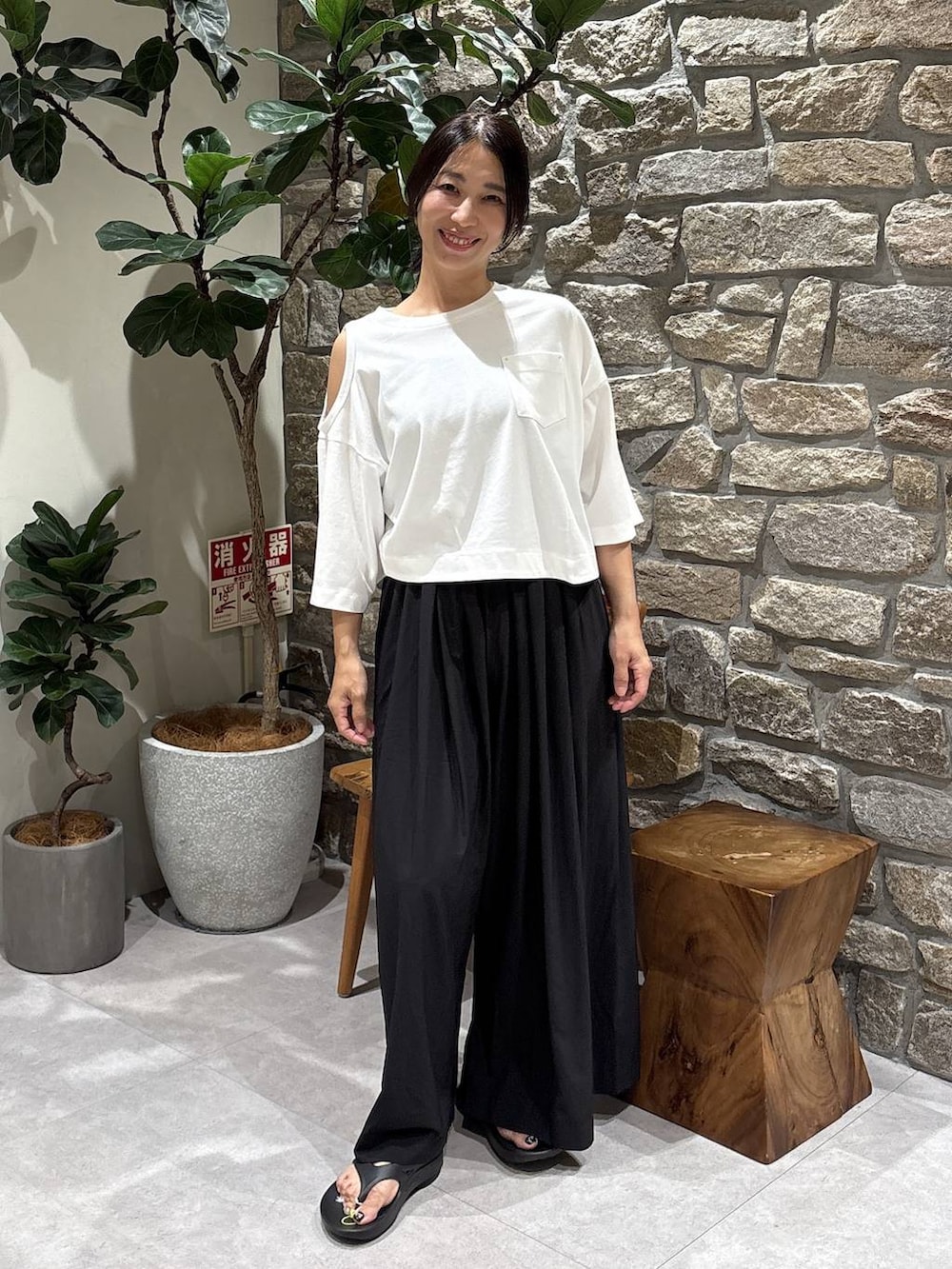 ホワイト系のTシャツ/カットソー、ブラック系のその他パンツ、ブラック系のサンダルを着用したレディースの夏コーディネートの2枚目の写真