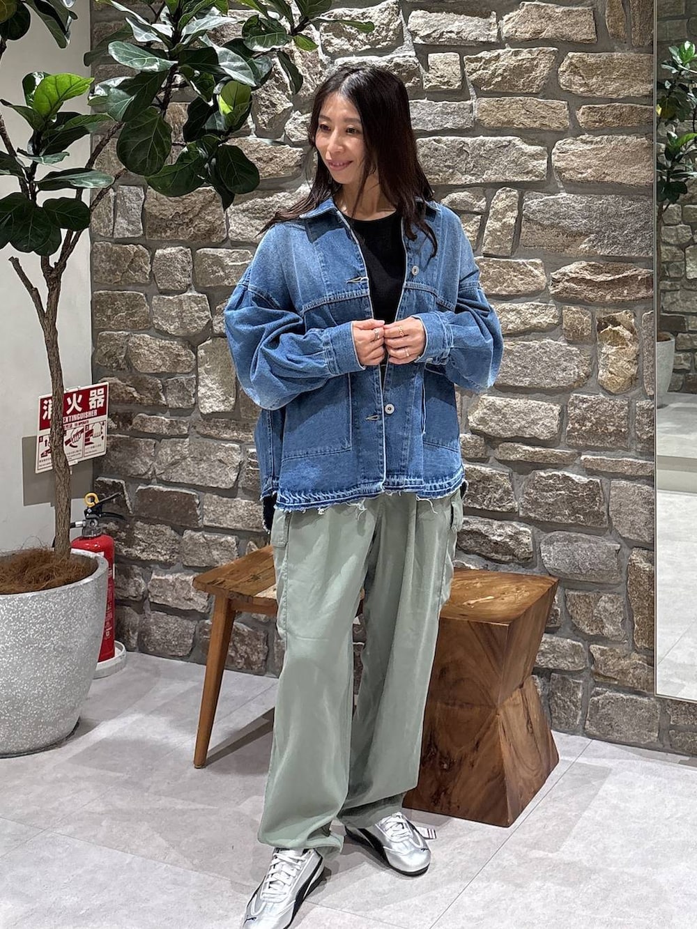 グレー系のスニーカー、グリーン系のカーゴパンツ、ブルー系のデニムジャケットを着用したレディースの春コーディネートの2枚目の写真