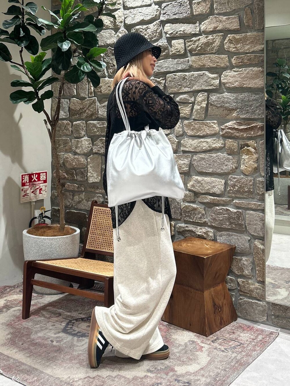 グレー系のトートバッグ、ベージュ系のスウェットパンツ、ブラック系のシャツ/ブラウスを着用したレディースの春コーディネートの2枚目の写真