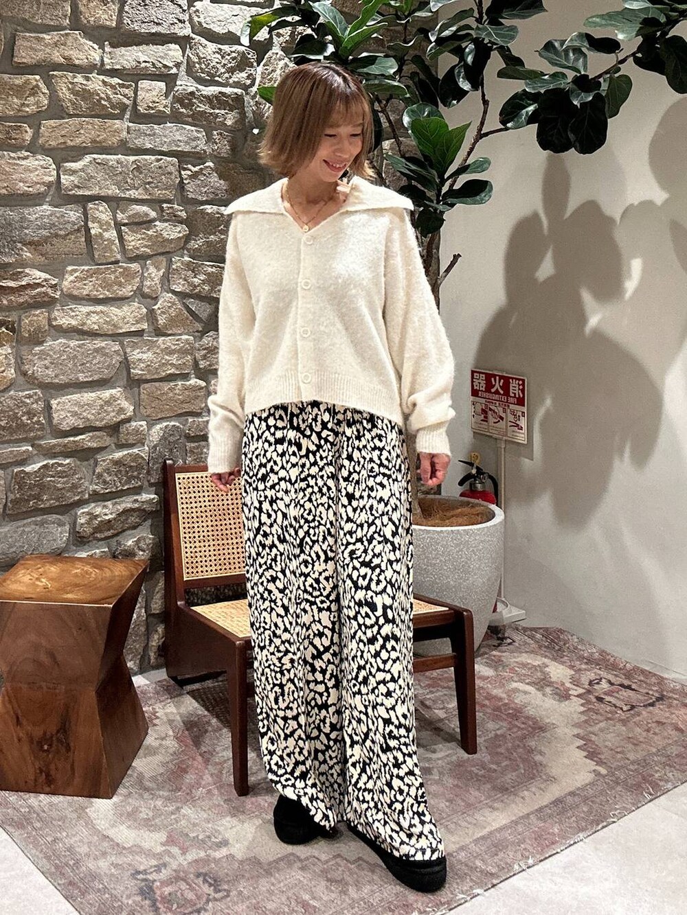 ブラック系のブーツ、ホワイト系のニット/セーター、ベージュ系のその他パンツを着用したレディースの秋コーディネートの2枚目の写真