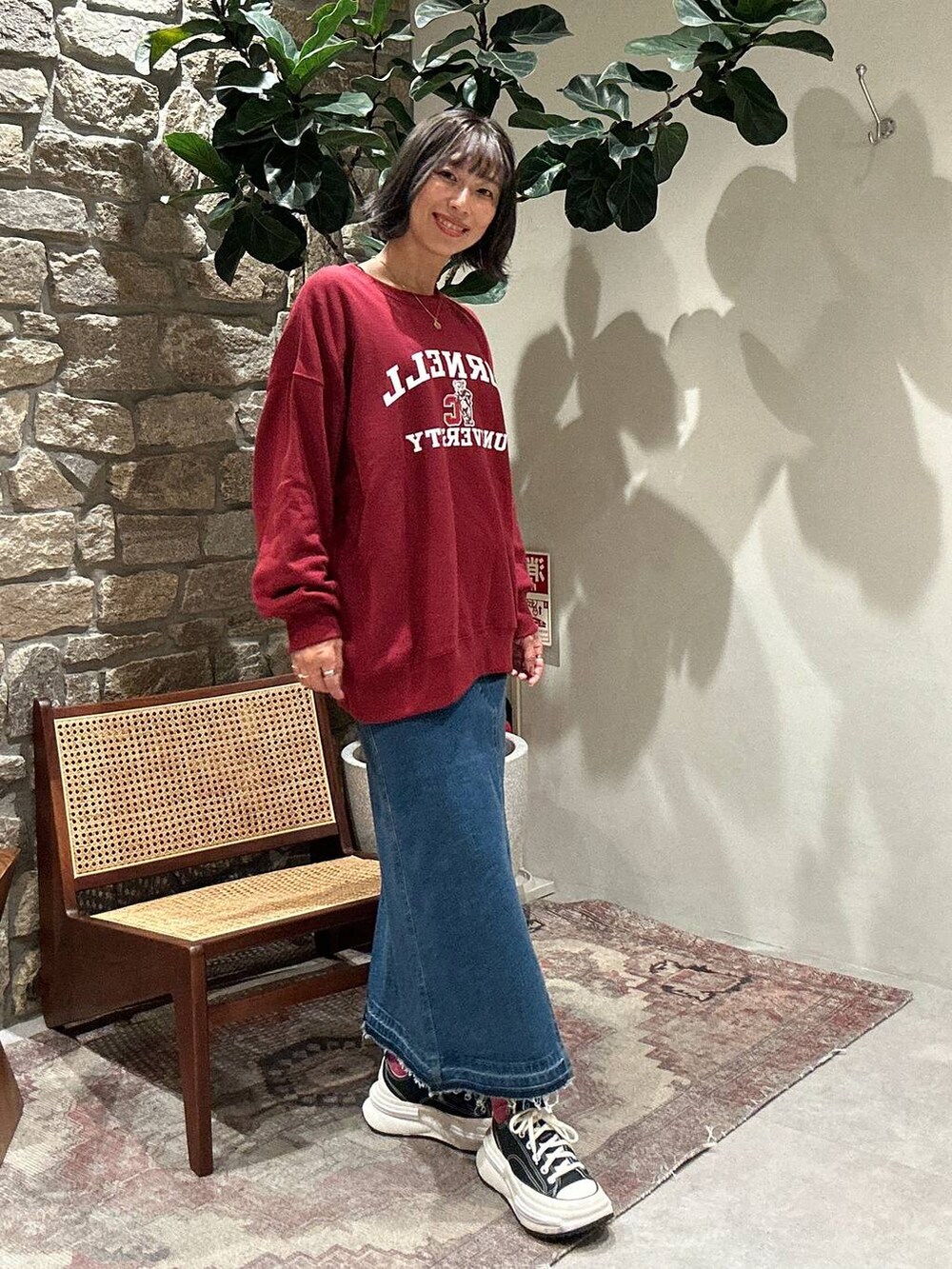 ブルー系のデニムスカート、レッド系のスウェットを着用したレディースの秋コーディネートの2枚目の写真