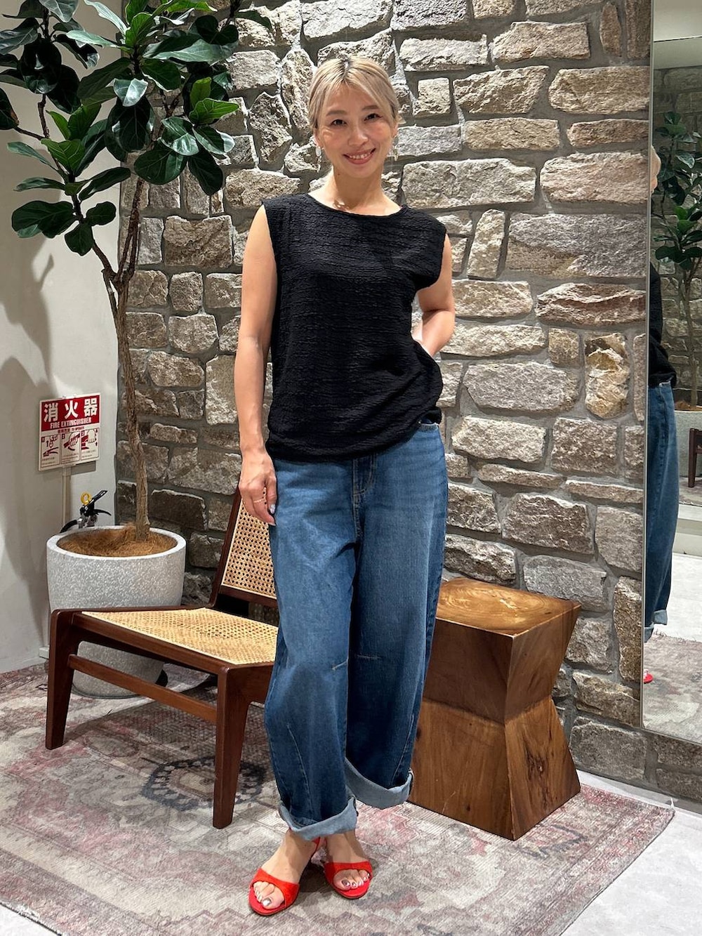 ブルー系のデニムパンツ、レッド系のサンダル、ブラック系のTシャツ/カットソーを着用したレディースの夏コーディネートの2枚目の写真
