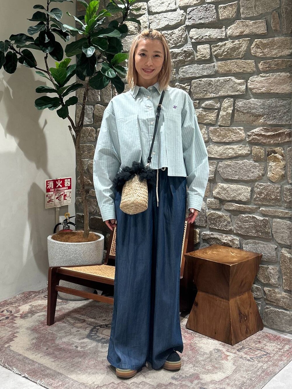 グリーン系のシャツ/ブラウス、ブルー系のその他パンツ、ブラック系のかごバッグを着用したレディースの春コーディネートの3枚目の写真