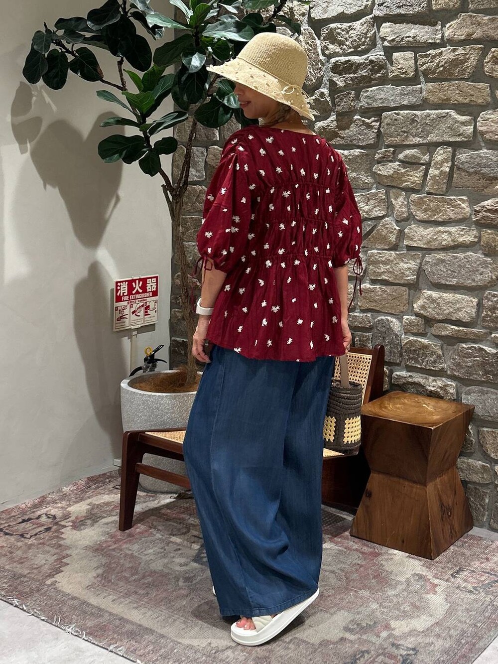 ブラウン系のショルダーバッグ、ブルー系のその他パンツ、レッド系のシャツ/ブラウスを着用したレディースの夏コーディネートの3枚目の写真