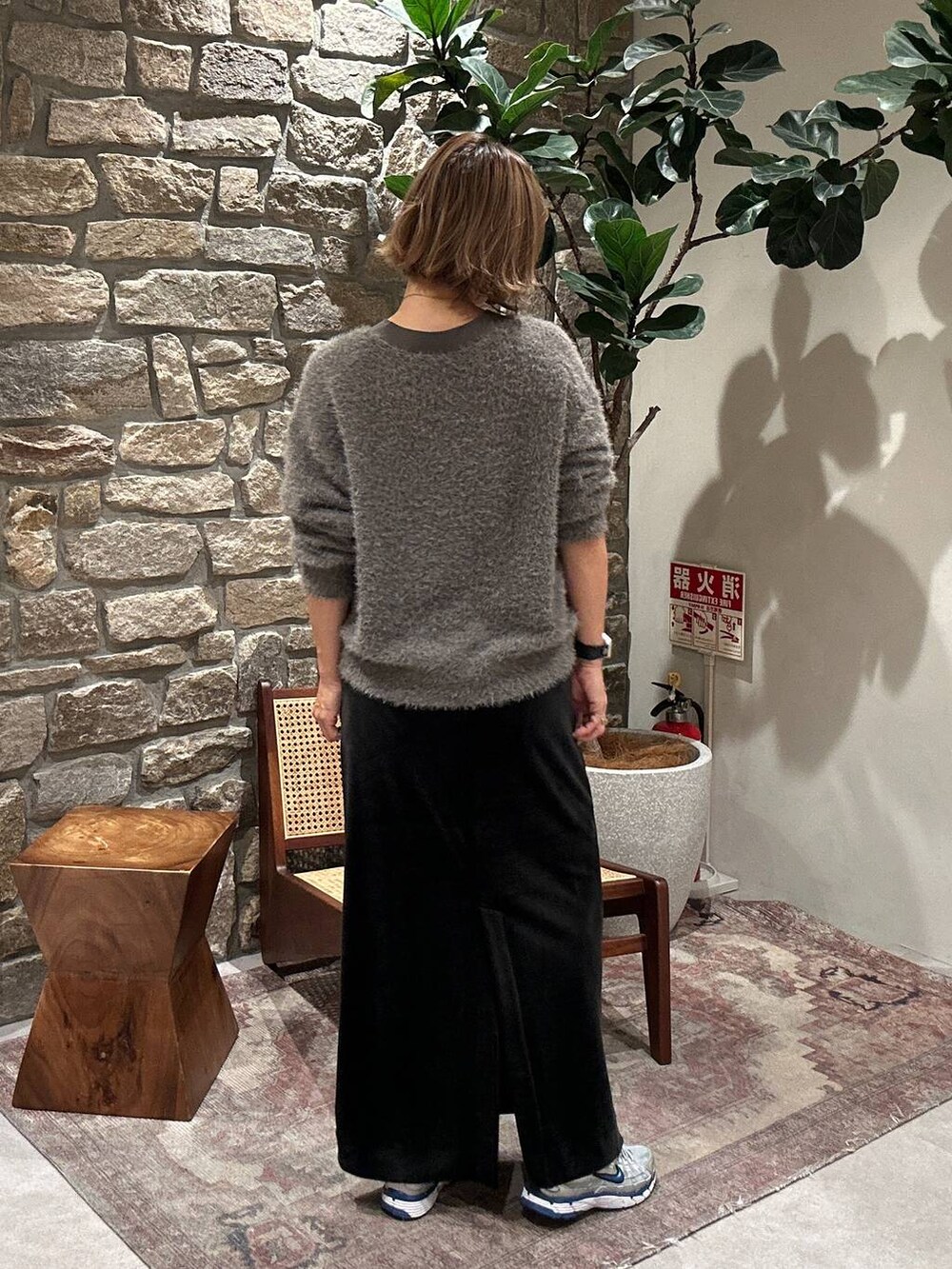 ブラック系のスカート、ブラウン系のカーディガン/ボレロを着用したレディースの秋コーディネートの2枚目の写真