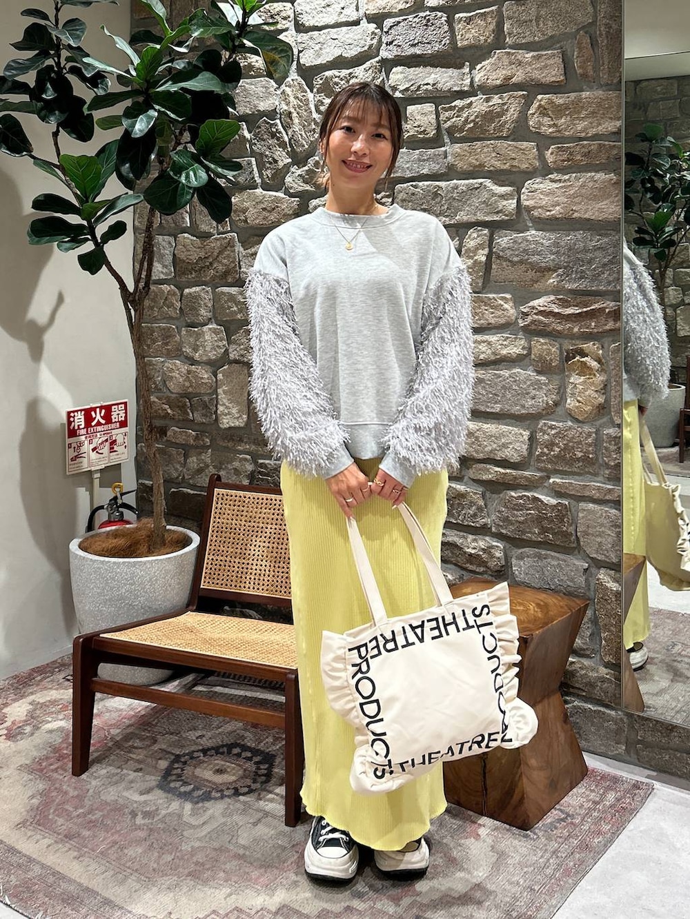 ベージュ系のトートバッグ、イエロー系のスカート、グレー系のスウェットを着用したレディースの冬コーディネートの2枚目の写真