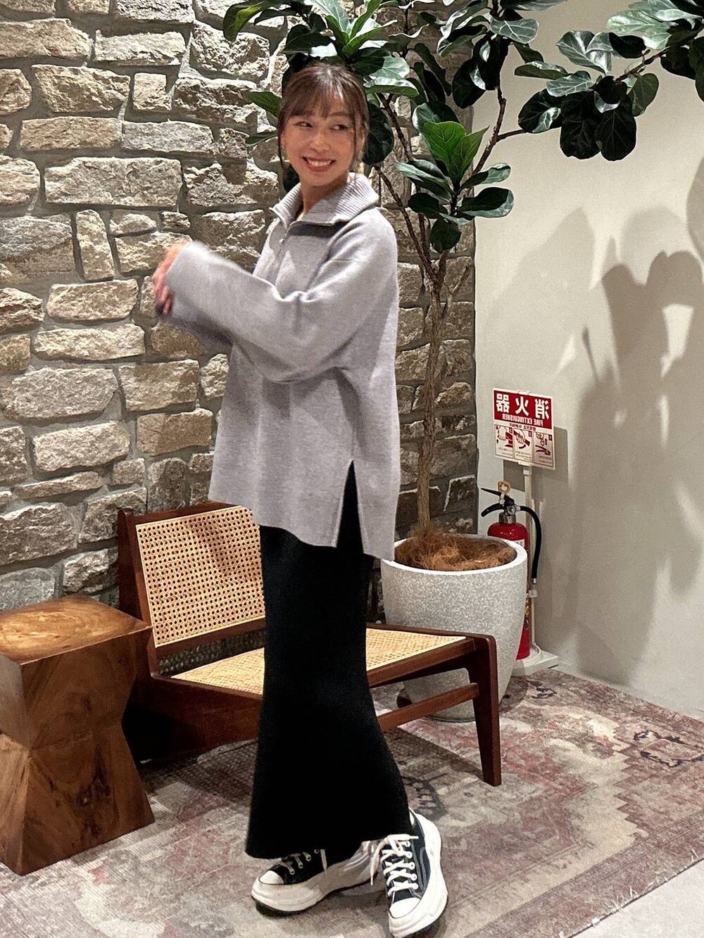 ブラック系のスカート、グレー系のニット/セーターを着用したレディースの秋コーディネートの3枚目の写真