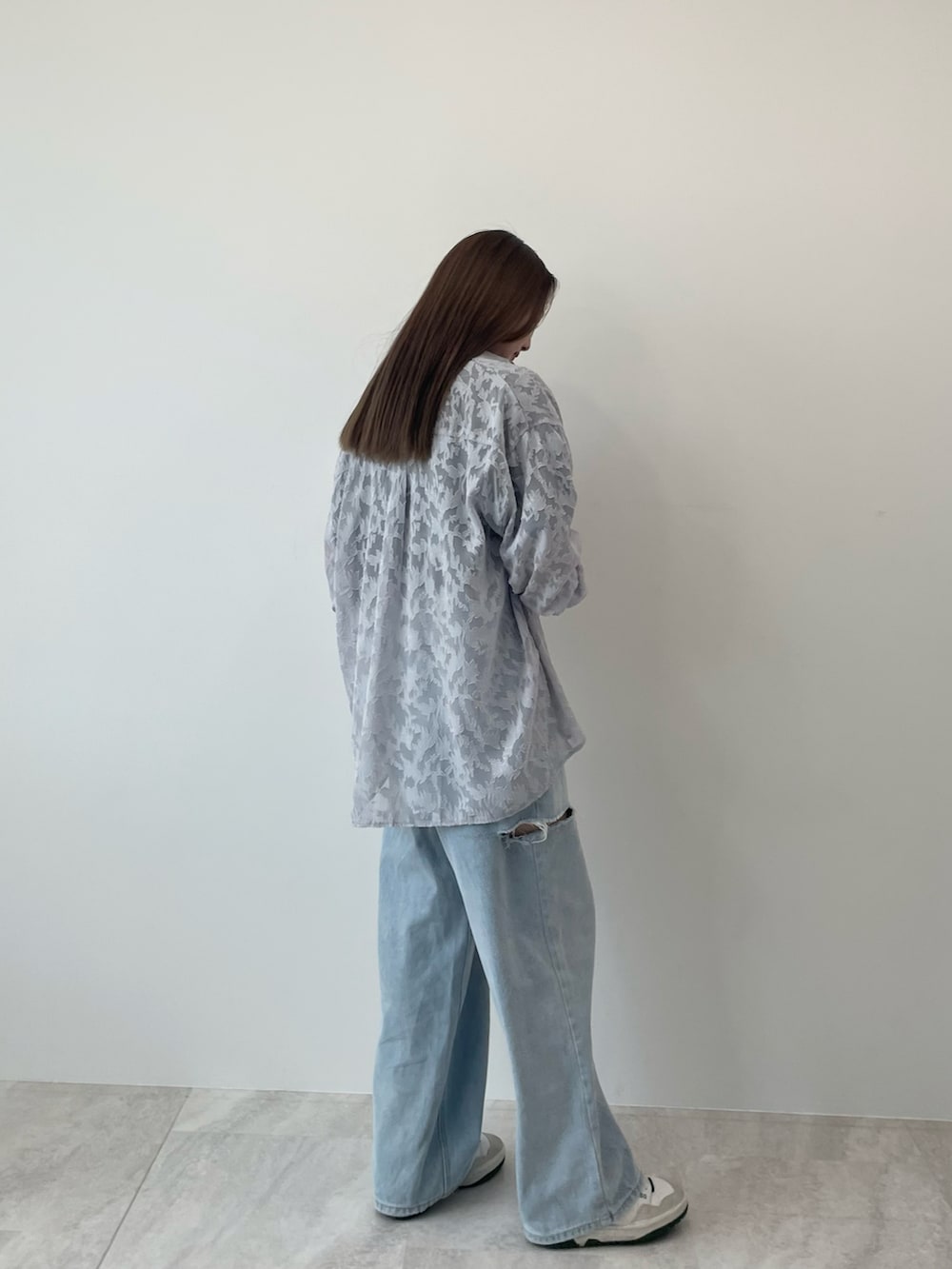 グレー系のシャツ/ブラウス、ブルー系のデニムパンツ、ホワイト系のスニーカーを着用したレディースの夏コーディネートの3枚目の写真